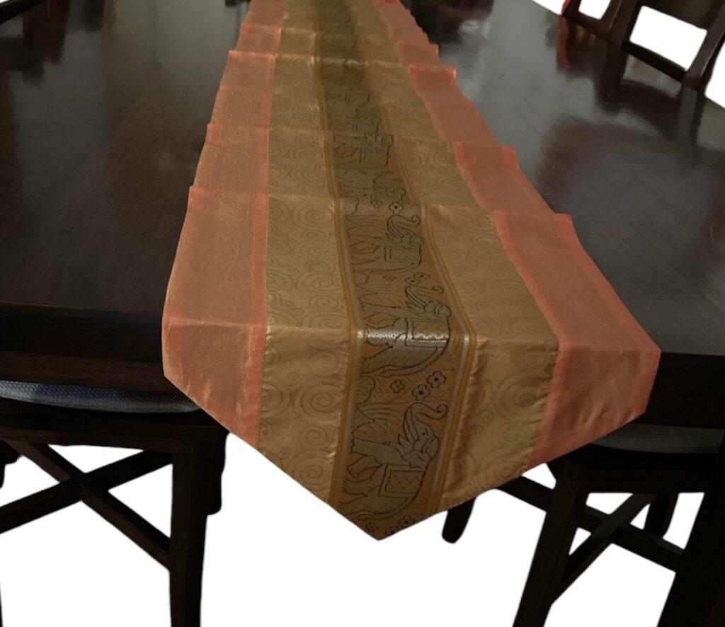 Thai Silk Table Runner with gold and coral tones, featuring an intricate elephant pattern with dimension : 79" x 13"