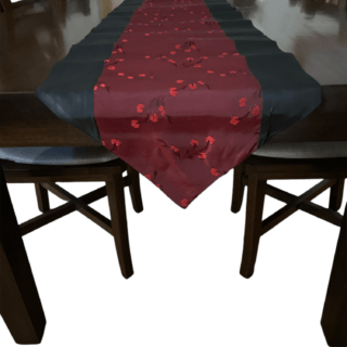 Decorative Thai silk table runner with deep red and black design featuring floral accents.